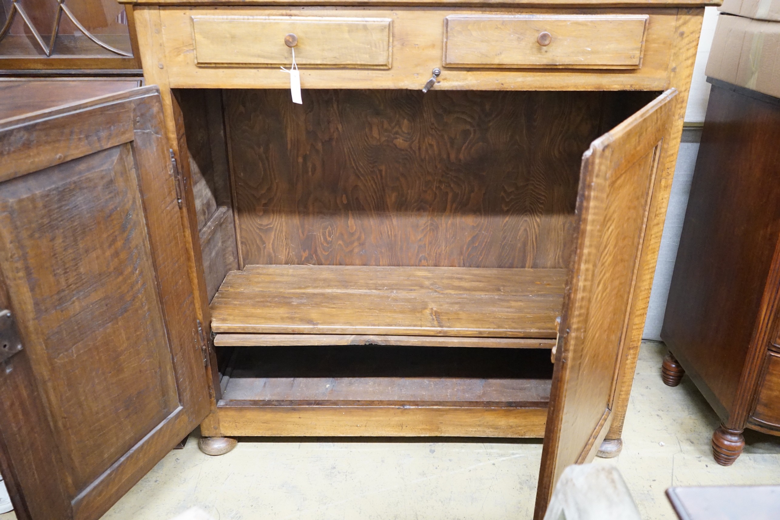 A late18th century continental fruitwood two drawer side cabinet, width 128cm, depth 47cm, height 128cm